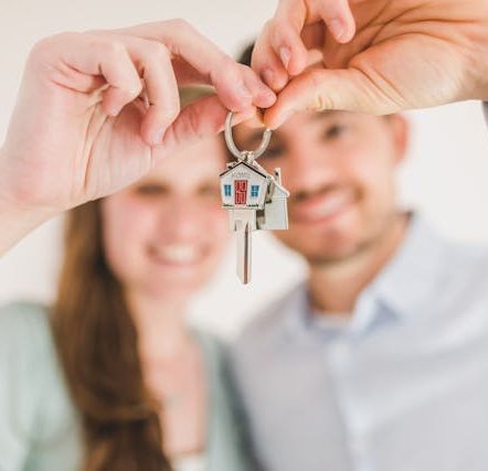 Happy Couple Holding and Showing a House Key